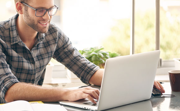 Chico sonriente utilizando un ordenador portátil