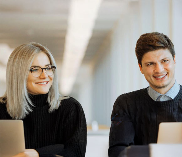 trabajadores sonrientes mirando ordenador